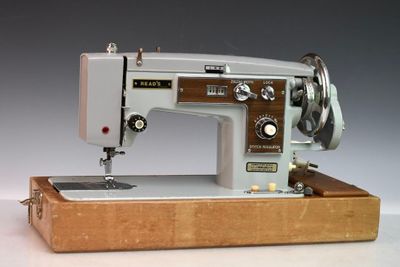 une machine à coudre posée sur un socle en bois