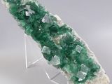 green and white crystals on a metal stand on a gray surface