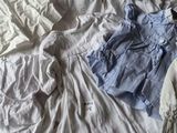 un lit sur lequel sont posés beaucoup de vêtements