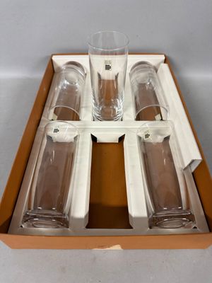 four empty glasses in a box on a table