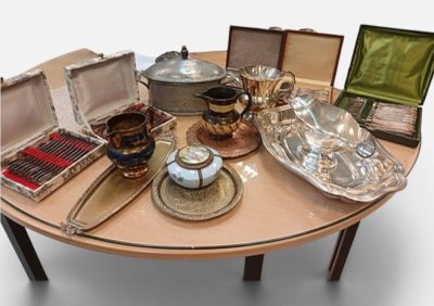 une table sur laquelle se trouvent de nombreux objets en argent