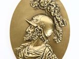 an image of a gold medallion with a woman wearing a hat