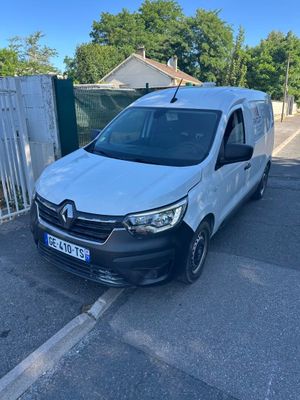 une camionnette blanche garée sur un parking près d'une clôture