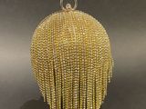 a gold beaded purse with a chain around it