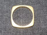 un gros plan d'une bague en or posée sur un tissu gris