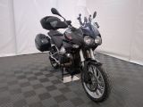 une moto qui est garée dans une pièce dont le sol est en damier