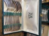 many forks and spoons in a case on the table