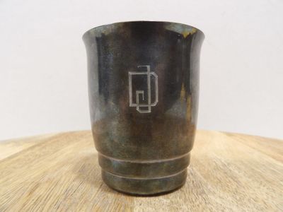une tasse en métal posée sur une table en bois