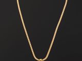 un collier en or avec une pièce de monnaie sur une chaîne