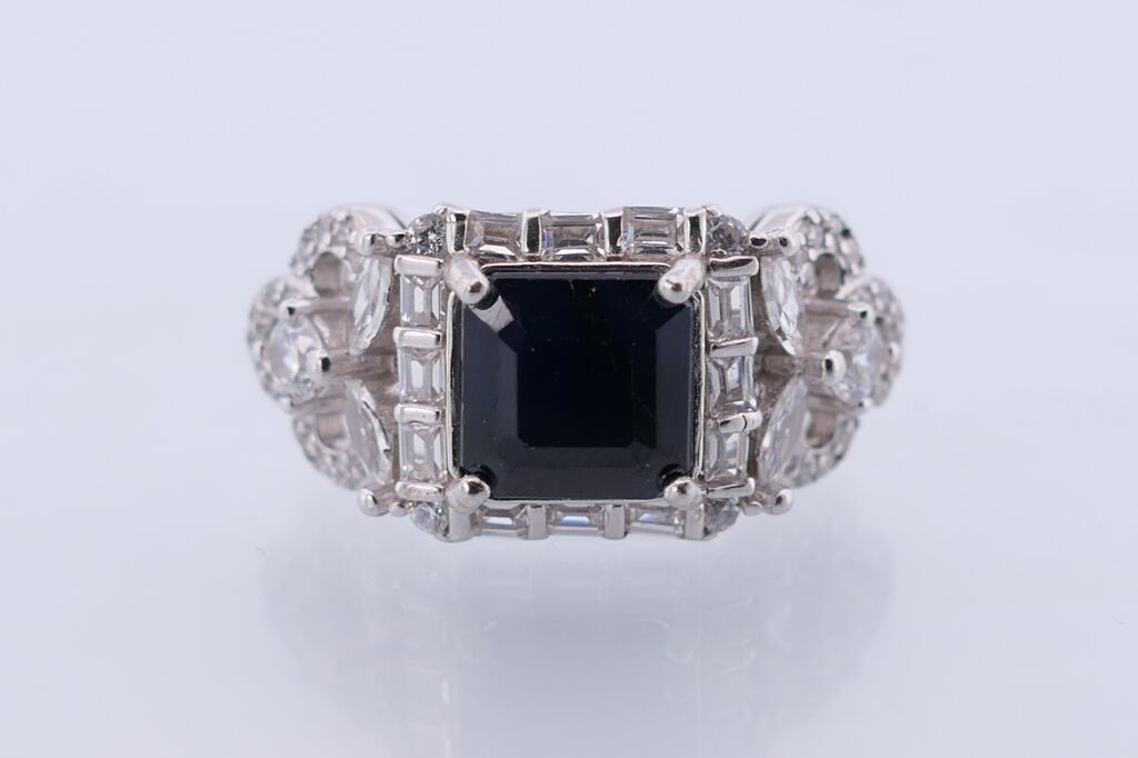 Bague en argent,sertie d'un saphir taille coussin dans un entourage de pierres blanches.TDD:7 PB:4,5gr.