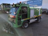 un camion-poubelle vert garé devant un immeuble
