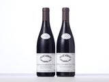 two bottles of red wine sitting on top of a table