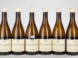 six bouteilles de vin sont alignées sur une table