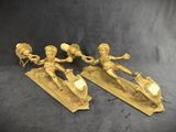 pair of antique brass figurines of a boy and a girl on a skateboard