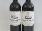 two bottles of red wine sitting next to each other on a table