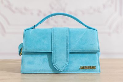 un petit sac à main bleu posé sur une table en bois