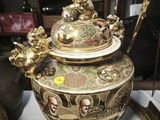a large gold vase sitting on top of a white table