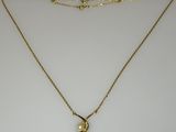 a gold necklace with a pearl pendant on a gold chain