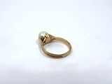 a close up of a gold ring with a pearl on it