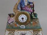 a figurine of a man sitting on top of a clock