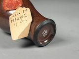 a small bottle with a piece of paper on it
