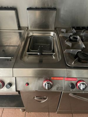 trois cuisinières en acier inoxydable dans une cuisine professionnelle