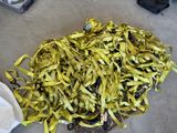 a pile of yellow ribbon on the ground next to a trash can