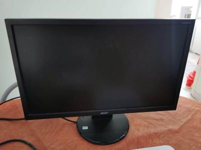 un écran d'ordinateur et un clavier posés sur une table