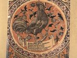 un vieux livre sur lequel figure l'image d'un coq