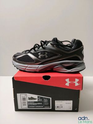 a pair of black and silver shoes sitting on top of a box