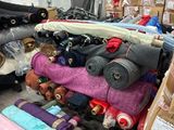 de nombreux rouleaux de tissu posés sur un chariot dans un entrepôt
