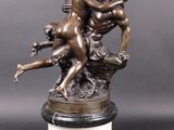 a bronze statue of a man and a woman on a pedestal