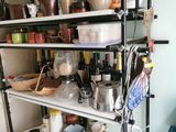 une étagère avec des casseroles et des poêles dans une cuisine