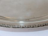a silver plate on a white table with a silver handle