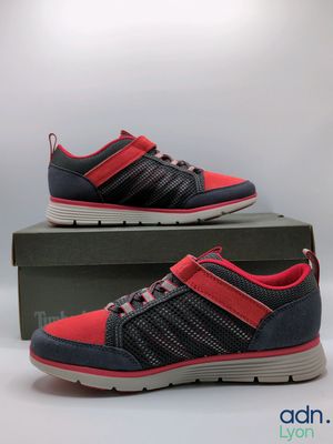a pair of red and grey shoes sitting on top of a box