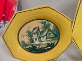 yellow plates with a picture of a house on them on a table