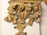 a gold clock on the wall next to a clock on the wall