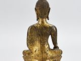 a gold buddha statue sitting on a wooden base on a white background