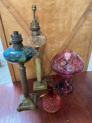 trois vases en verre et une lampe posés sur une table en bois