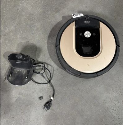 un robot posé par terre à côté d'un chargeur