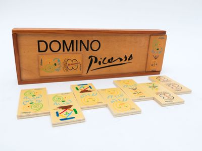 des dominos dans une boîte en bois posée sur une surface blanche
