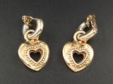 paire de boucles d'oreilles dorées en forme de cœur sur fond noir