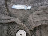 a close up of a sweater with a button on it