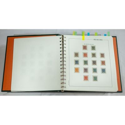 an open notebook with stamps on it sitting on top of a table