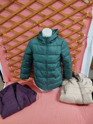 un manteau, un sac et un sac à main posés sur un lit