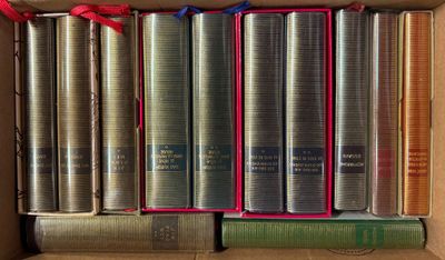 de nombreux livres dans une boîte, ornés de rubans rouges