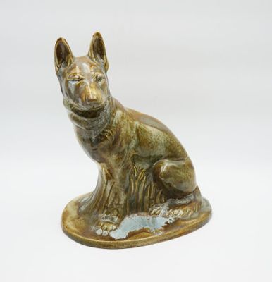 statue en bronze représentant un chien assis sur une surface blanche