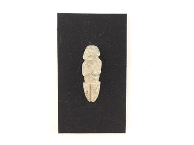 a small piece of stone sitting on top of a black surface