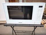 a white microwave sitting on a table in front of a brick wall