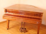 a piano sitting on a wooden floor in a room